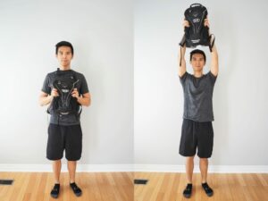 man using a backpack to perform a shoulder press exercise