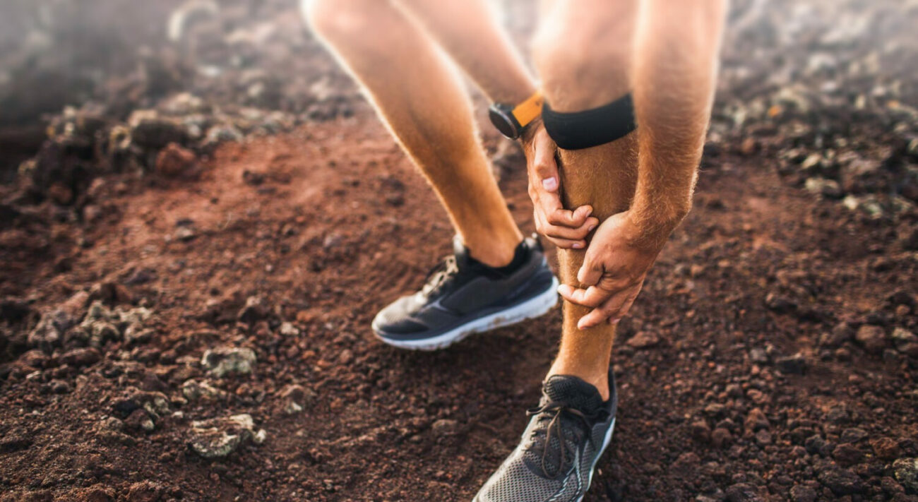 Male runner holding shin in pain due to shin splints