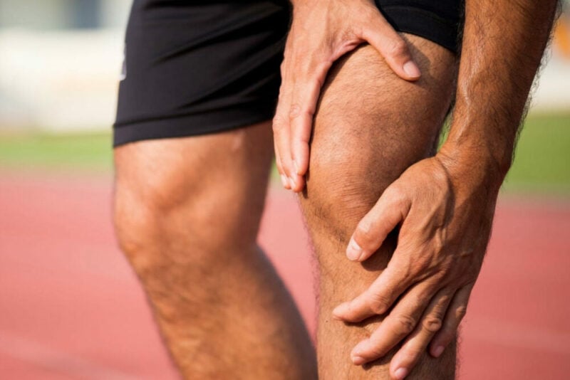 man holding his knee in pain due to runners knee or patellofemoral syndrome
