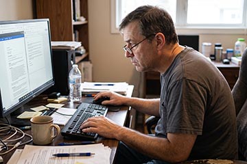 man-sitting-at-a-computer-desk-with-poor-posture