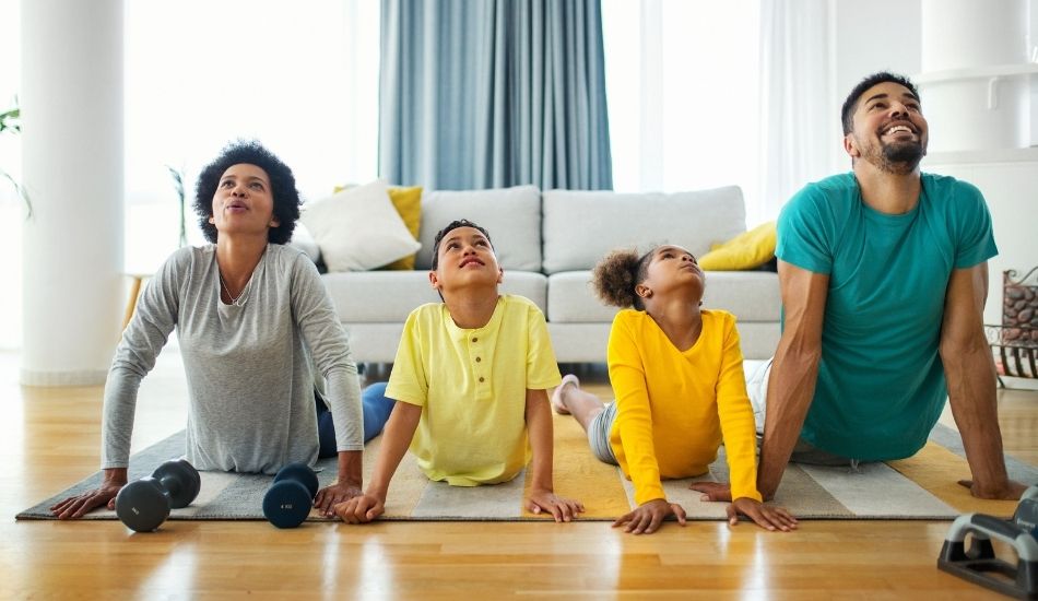 Family in living does yoga and stretching together
