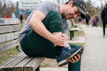 man-on-a-bench-holding-his-foot-in-pain-due-to-plantar-fasciitis-preview